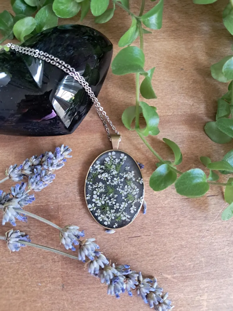 Médaillon noir orné de fleurs sechées